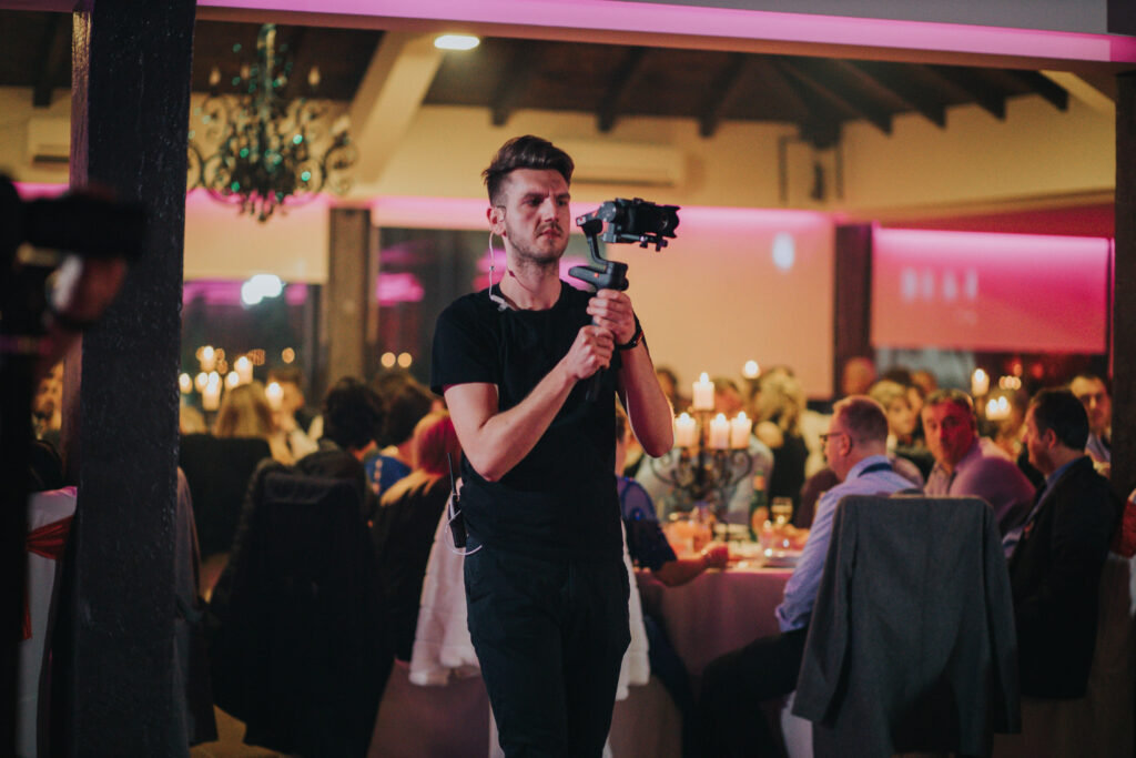 america community facelift Shallow focus of a young cameraman filming a wedding celebration in a restaurant